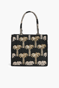 Black tote bag with gold palm tree patterns on a white background