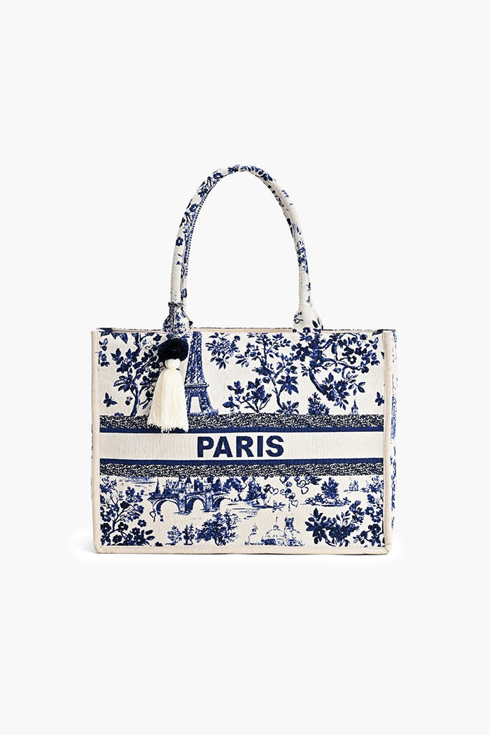 A structured tote bag featuring a blue and white toile pattern with the word 'PARIS' printed across the center, set against a plain white background.