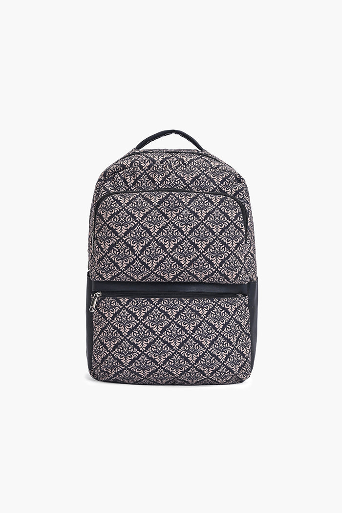 A backpack with a black and white geometric diamond pattern, featuring a top handle, a front zippered pocket, and black side panels, shown against a plain white background.